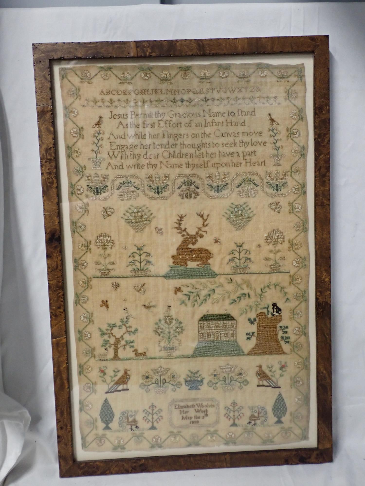 1823 Elizabeth Woolvin Sampler: Elizabeth Woolvin Her Work May the 9th 1823. Religious verse at top. Alphabet. Motif house, Stag birds Flowers. Vine and flower border. Fabric discoloration. Frame 22 1/4 x 14 1/2 Sampler 20 x 12
