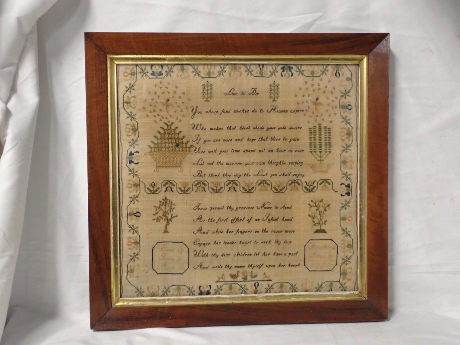 1856 Emma Tandy Sampler: Emma Tandy Aged 10 Tiverton (?) School 1856. Religious verse "Live to DIe" Motif Baskets of flowers birds animals . Vine and floral border. Frame 16 1/4 x 16 3/4. Sampler 12 3/4 x 13 1/2