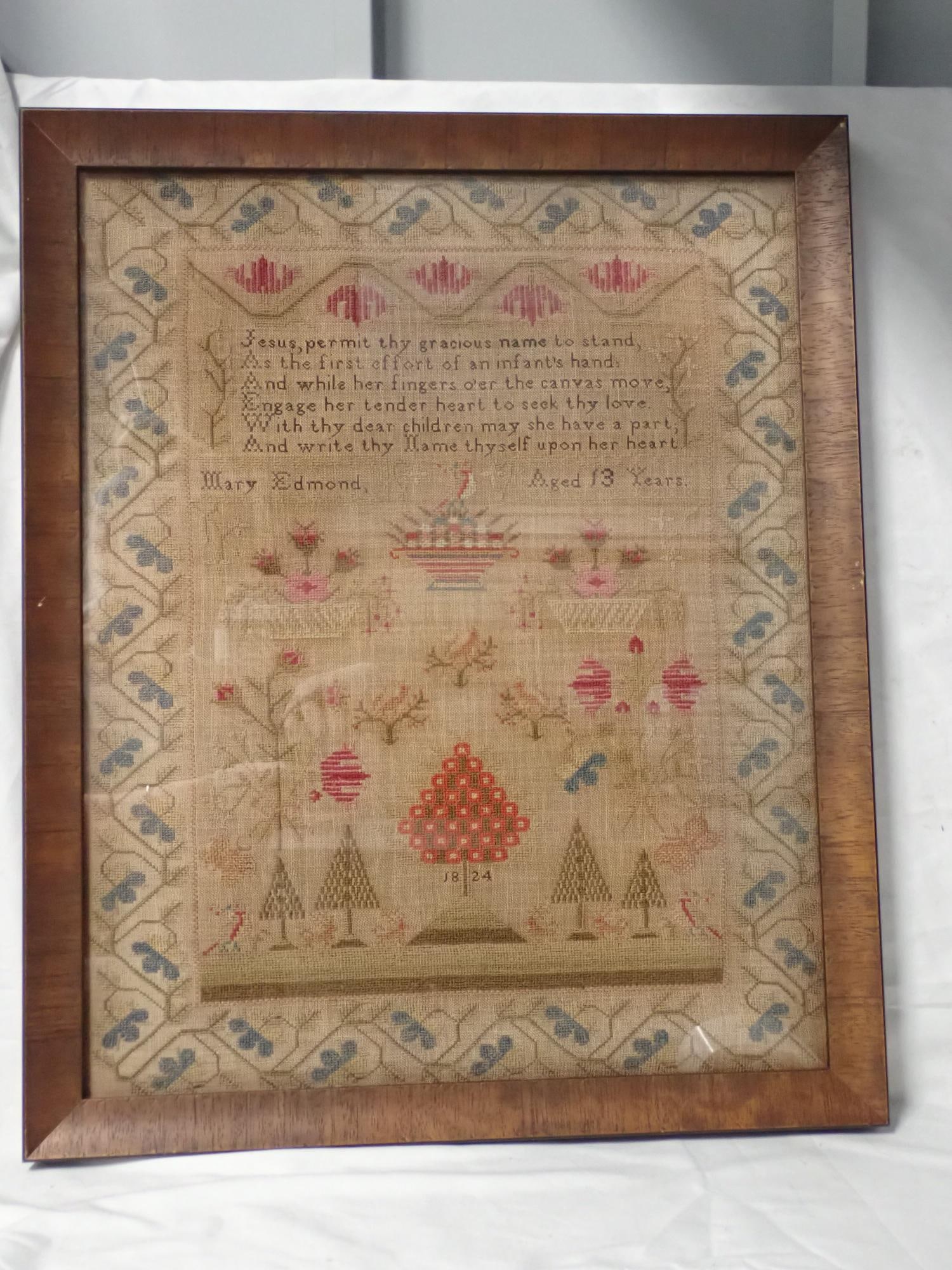 1824 Mary Edmond Sampler: Mary Edmond Aged 13 1824. Religious verse in top. Motif Floral baskets, birds butterflies trees and animals Vince and floral border. Fabric discoloration. Frame 23 x 19 Sampler 20 1/2 x 16 1/2