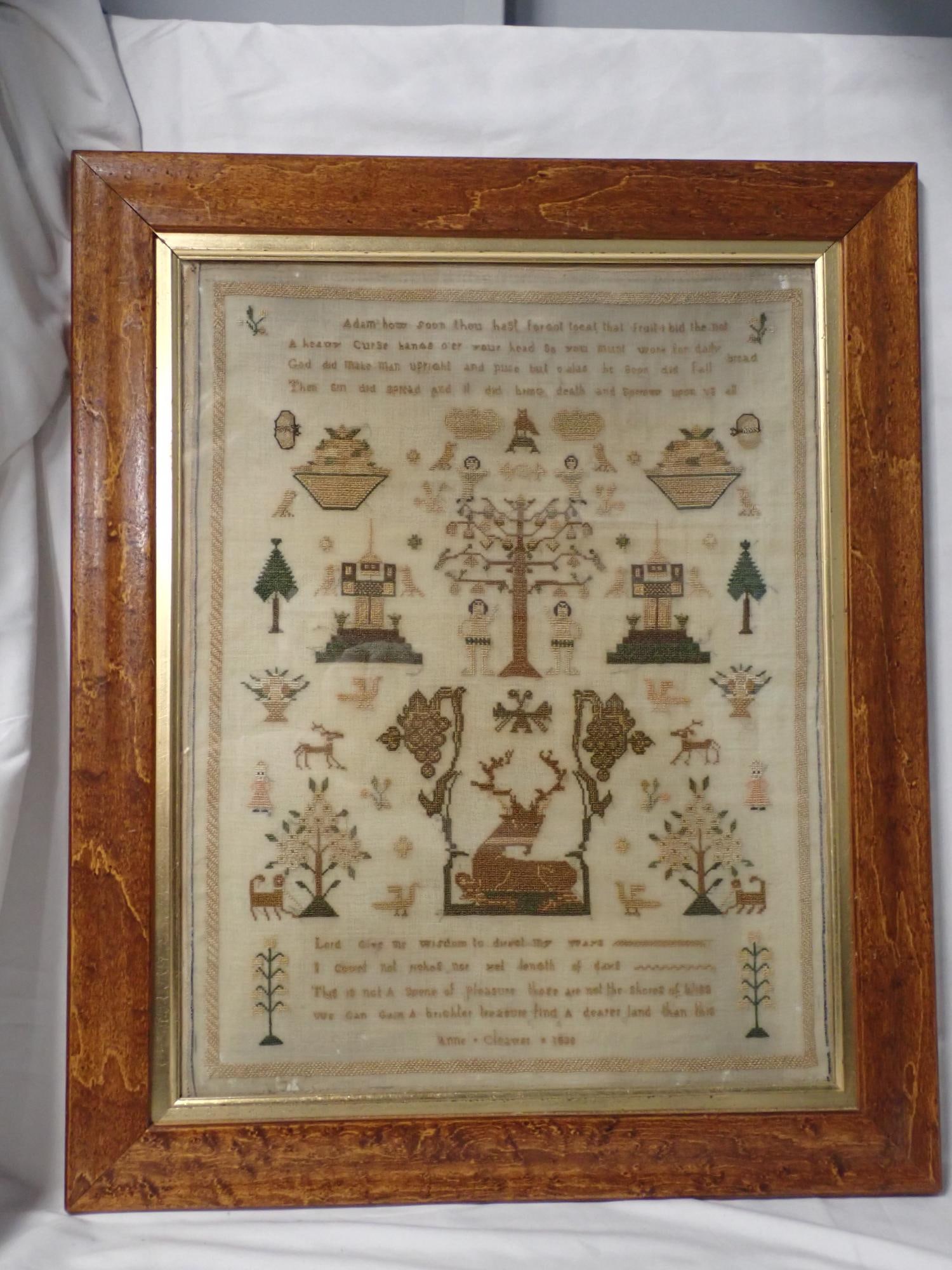 1830 Anne Cleaver Sampler: Ann Cleaver 1830. Religious verse at top and bottom. Motif Adam and Eve, trees, baskets flowers, fruit stags, trees, animals. Fabric loss and staining. Palin stitched border Frame 21 1/2 x 17 1/2
