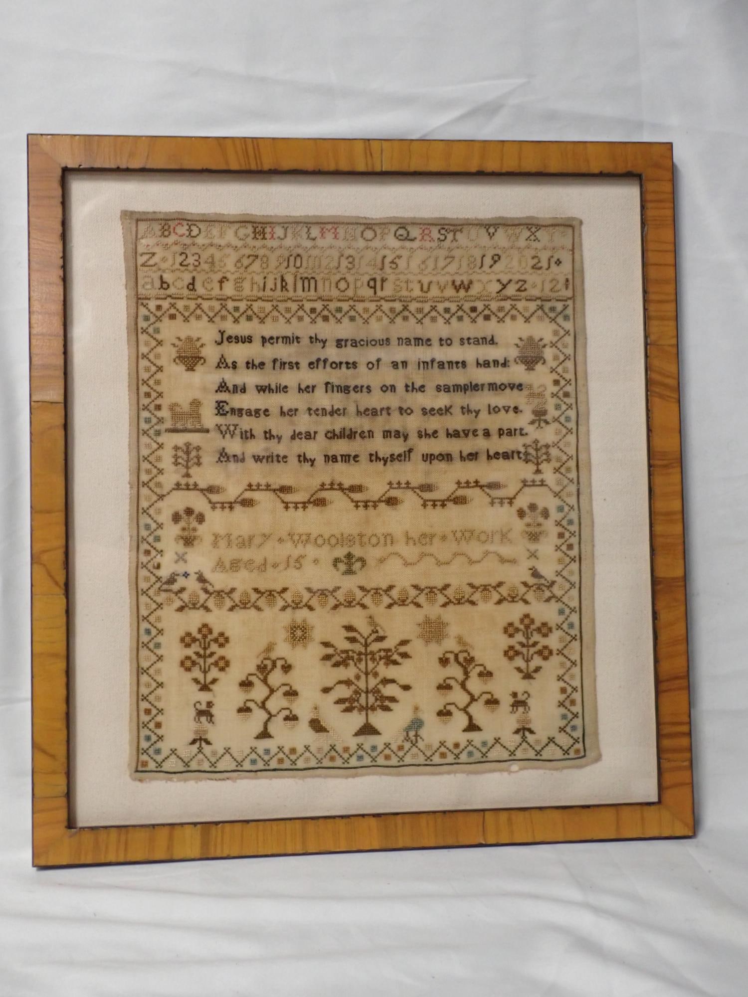 Mary Woolson no date (possibly 19th Century: Mary Woolson her work Aged 15. Religious verse in center. Alphabet and numbers. Motif flowers, birds, animals. Geometrical border. Fabric discoloration and some thread bleeding. Frame 15 3/4 x 14 1/2