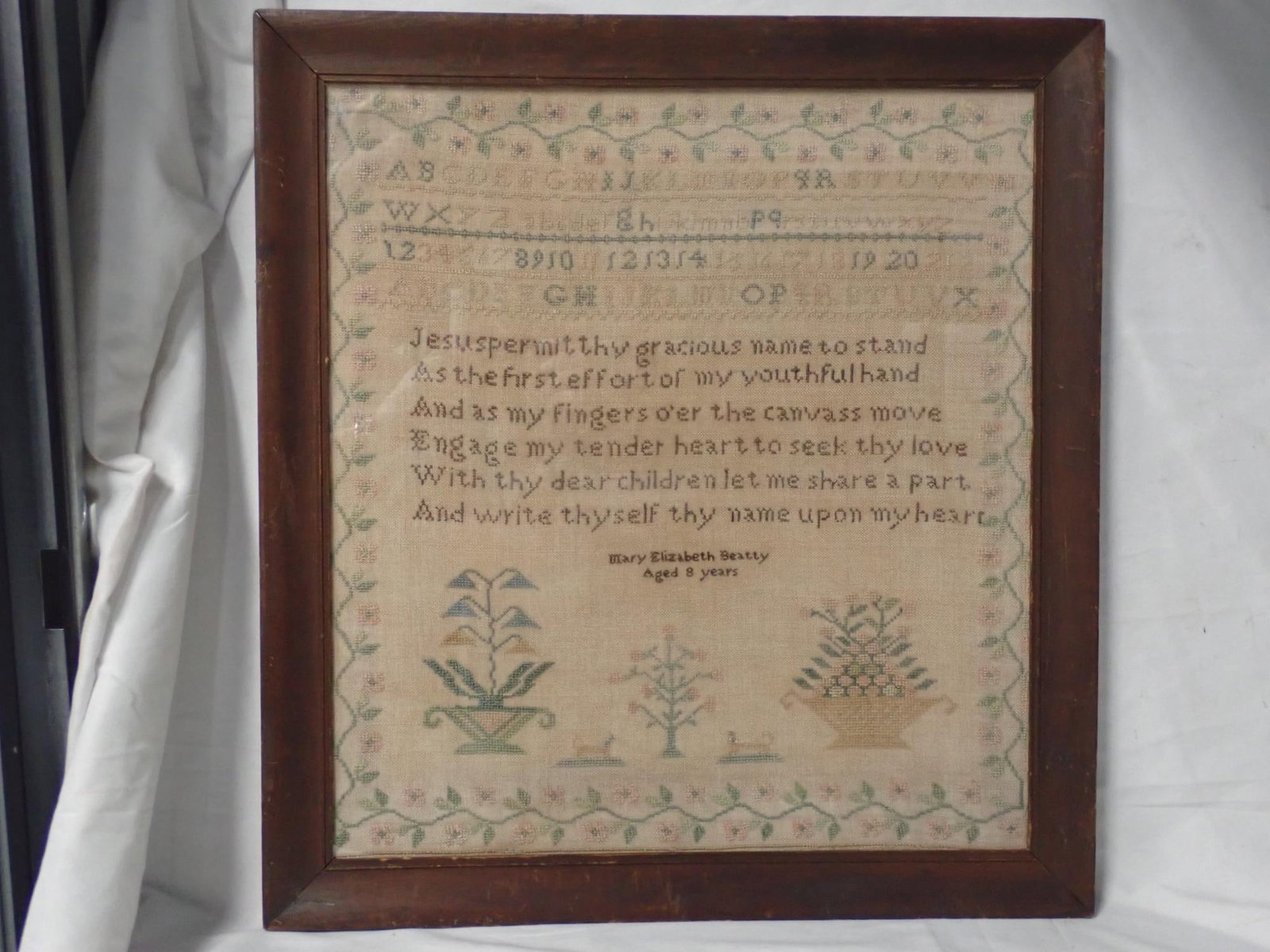 Mary Elizabeth Beatty Sample: Mary Elizabeth Beatty Aged 8 years. Alphabet and numbers, Motif flowers and baskets animals. Vine and floral border Frame 20 1/4 x 18 3/4 Sampler 17 1/4 x 15 3/4