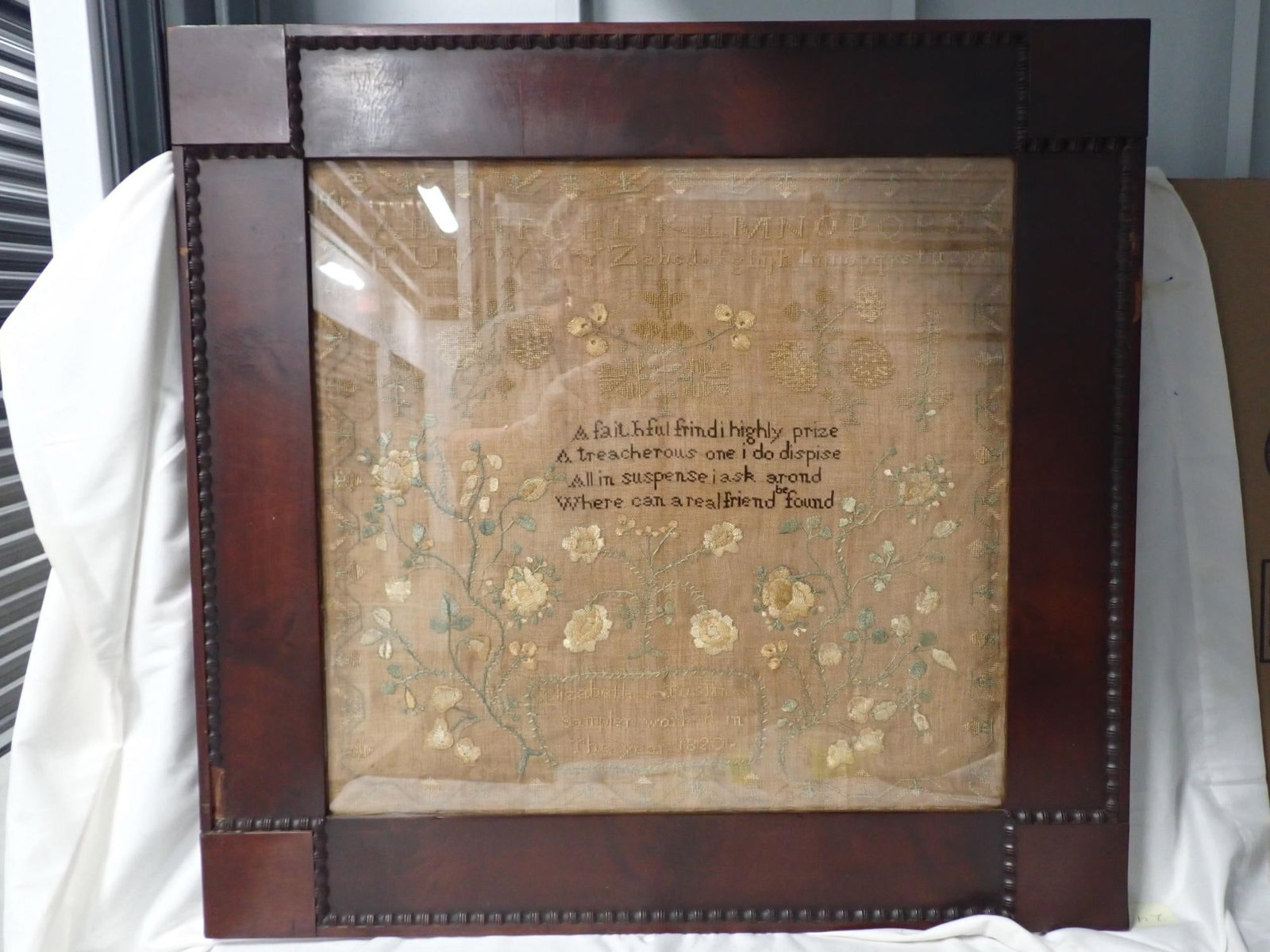 1820 Elizabeth Tuston Sampler: Elizabeth Tuston sampler worked in the year 1820. Verse in center. Alphabet Motif floral. Vine and flower border. Fabric discoloration and some fading of thread. Frame 28 x 29 Sampler 20 1/4 x 21 1/2