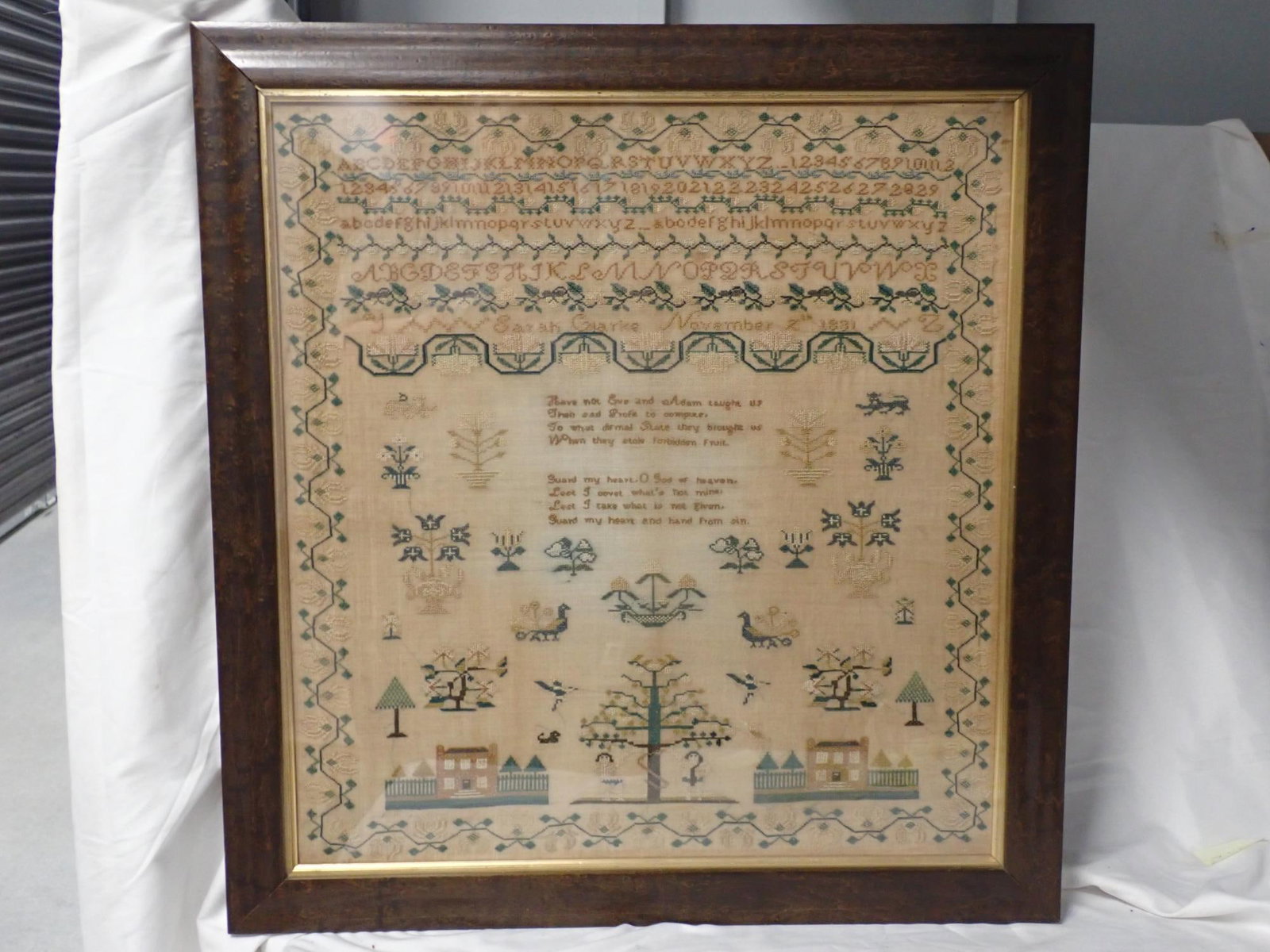 1831 Sarah Clarke Sampler: Sarah Clarke November 2nd 1831. Alphabet, numbers, Religious verse in center. Motif lions, peacocks birds trees houses. Vine and floral border. Some fabric discoloration. Frame 25 3/4 x 24 1/2 Sampler