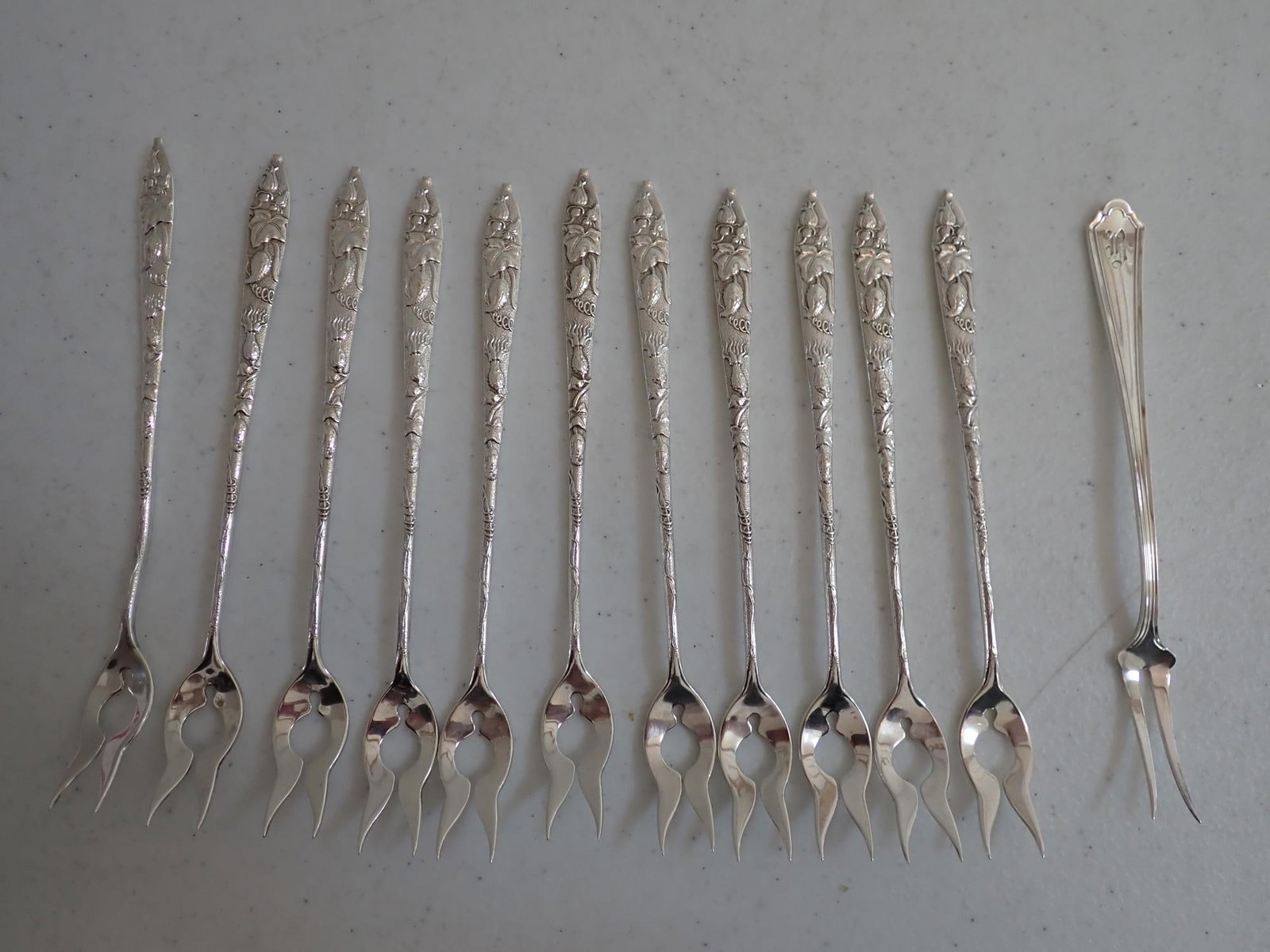 11 Tiffany & Co. Cocktail Forks + 1 A. Stowell & Co: Tiffany measure 6" and the A. Stowell & Co. measures 5 3/4." 7.3 troy ounces.