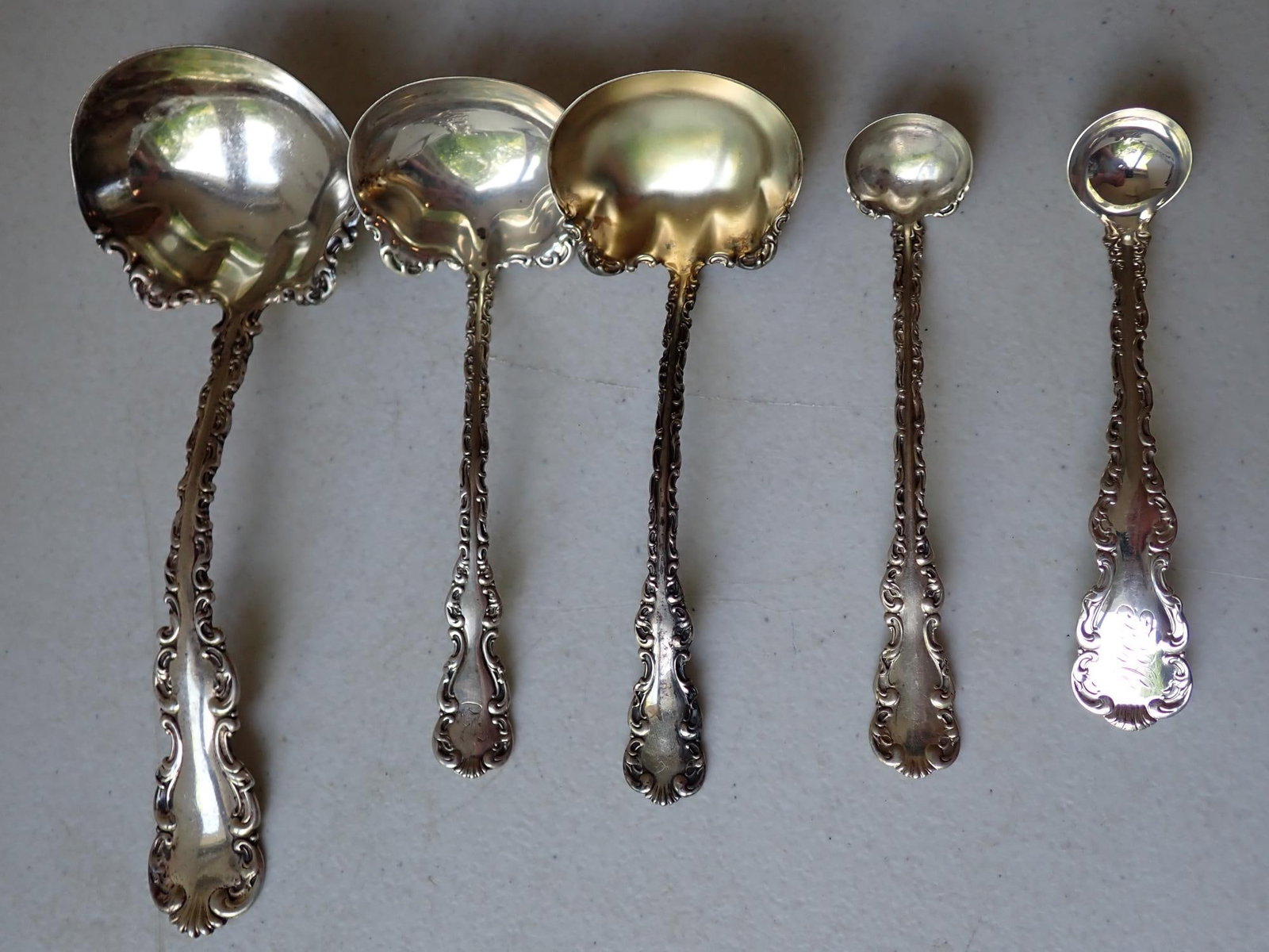 5 Whiting Gorham Louis XV Sterling Ladles: (1) 7 1/4", (2) 5 1/2", (1) 5" and (1) 4 1/2." 4.7 troy ounces.