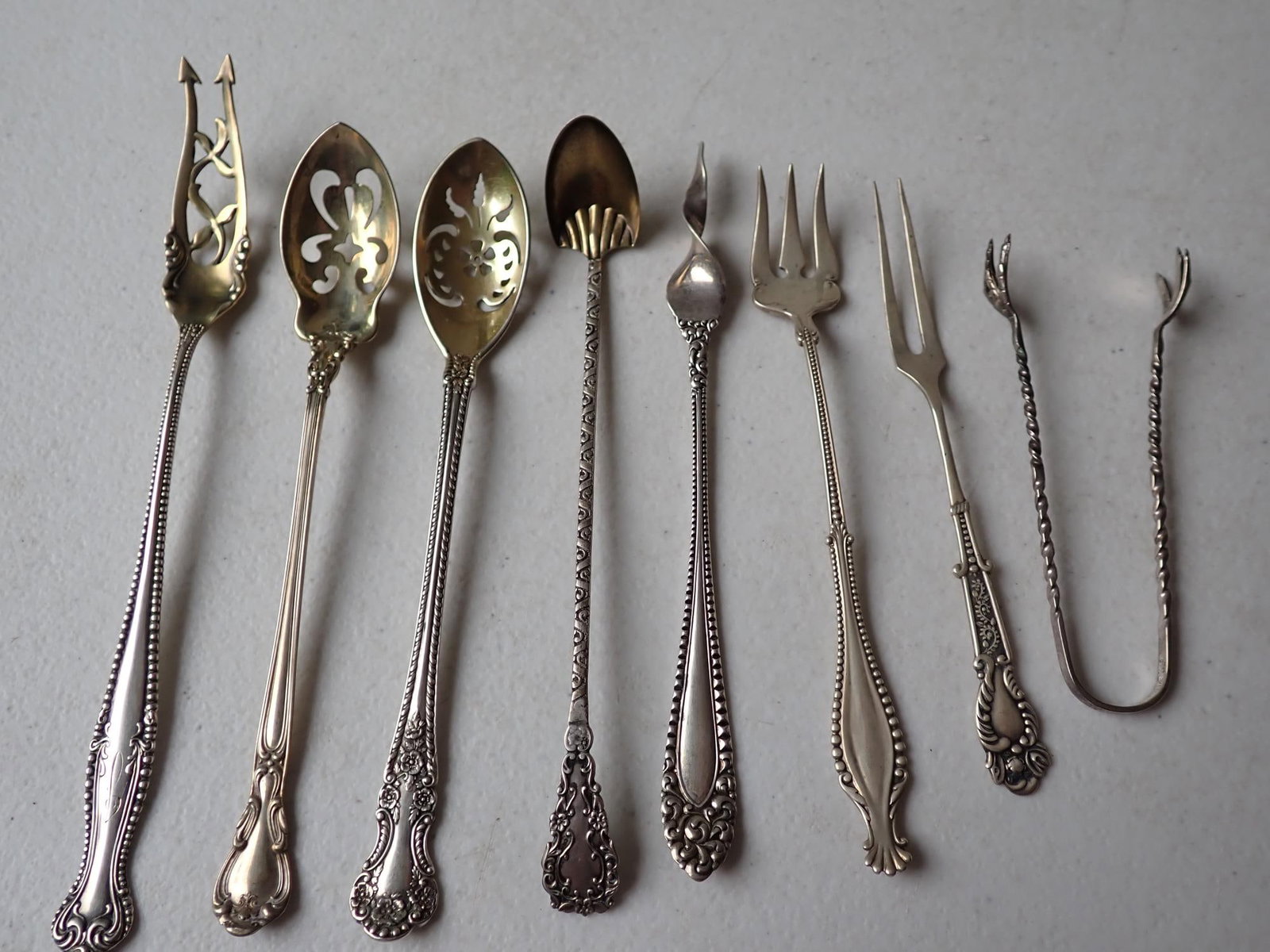 Sterling Silver Serving Pieces: Sterling Tongs, Twirled Spear, Fork Slotted Spoons, Scoop, Serving Forks. 3.0 troy ounces.