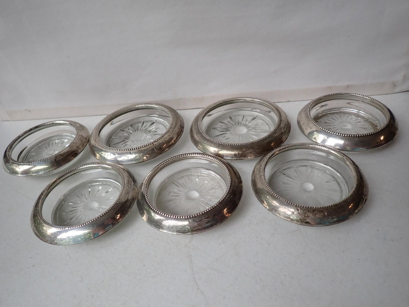 7 Frank M. Whiting & Co Sterling & Glass Coasters: 05 Pat Pending. (2) 4 1/2" and (5) 4" Glass and Sterling Coasters