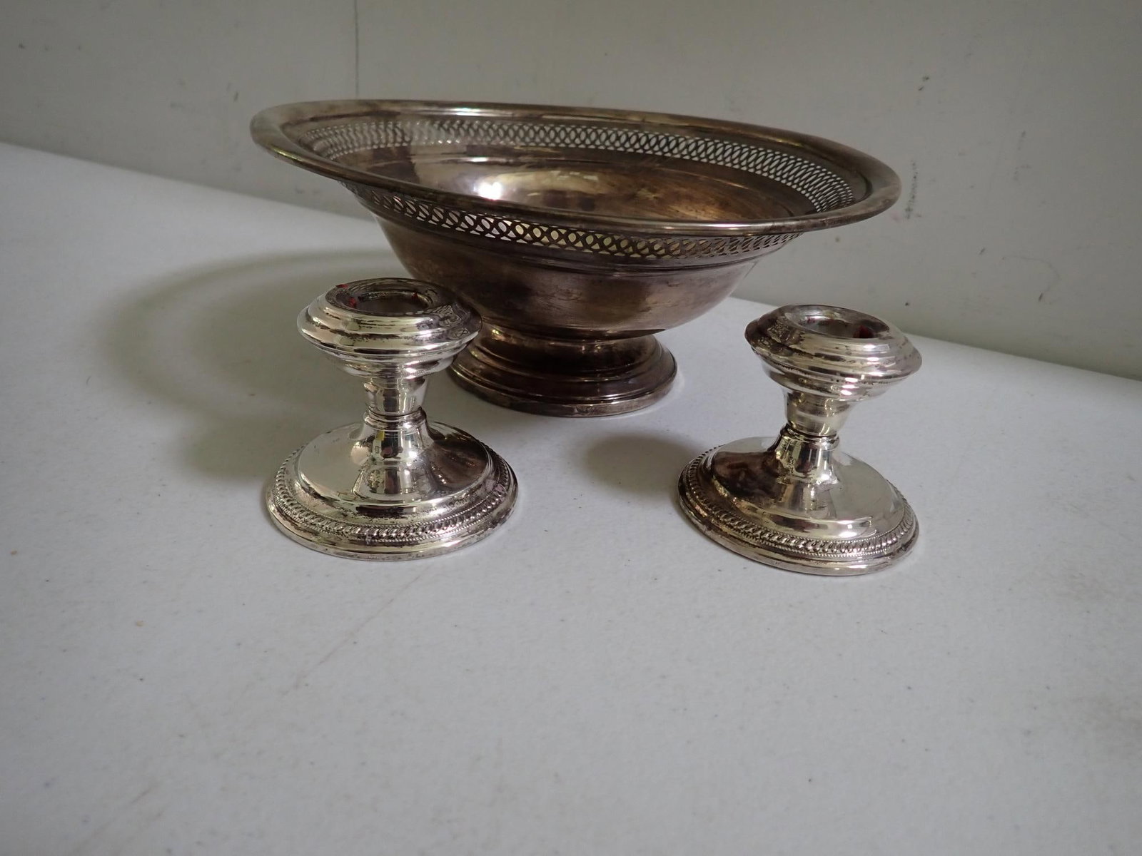 Weighted Sterling Footed Bowl & candleholders: Reticulated Bowl 9" diameter. 3 1/2" high. Small dent on ball and minor dents on base. Candle holders approximately 2" high.