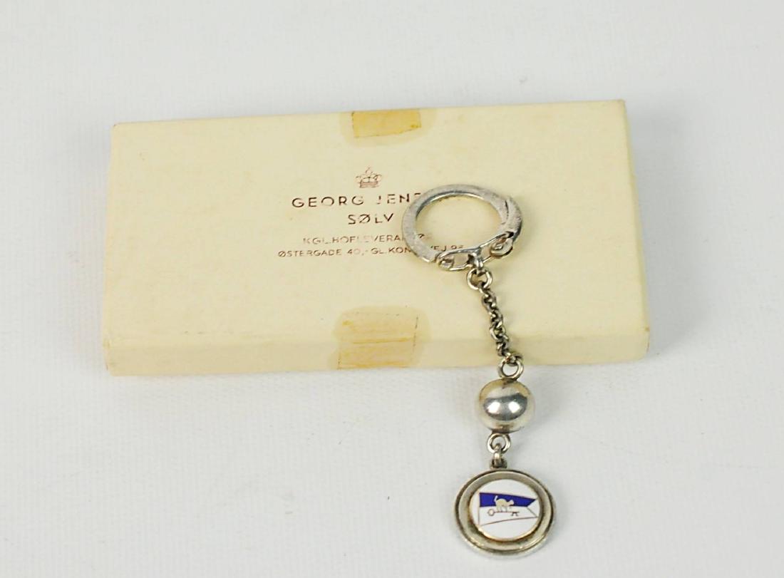 Georg Jensen Vintage Sterling Enamel Key Ring: Georg Jensen key ring "Cat Cay" in sterling silver with an enamel nautical flag boasting a Cat on a Key for Cat Cay. With original box Size: 3.5" L. Condition: Good. Please examine all photos closely.