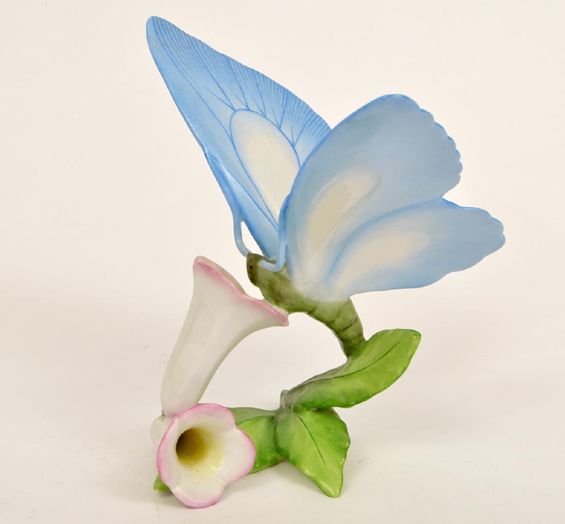 Herend Porcelain Butterfly on Trumpet Flower: Herend blue porcelain butterfly on pink trumpet flowers. Marked: Herend, Hungary. 5.75"H. Condition: Very Good - no chips or cracks. Please examine all photos closely. Contact C. Biddle Auction Galler