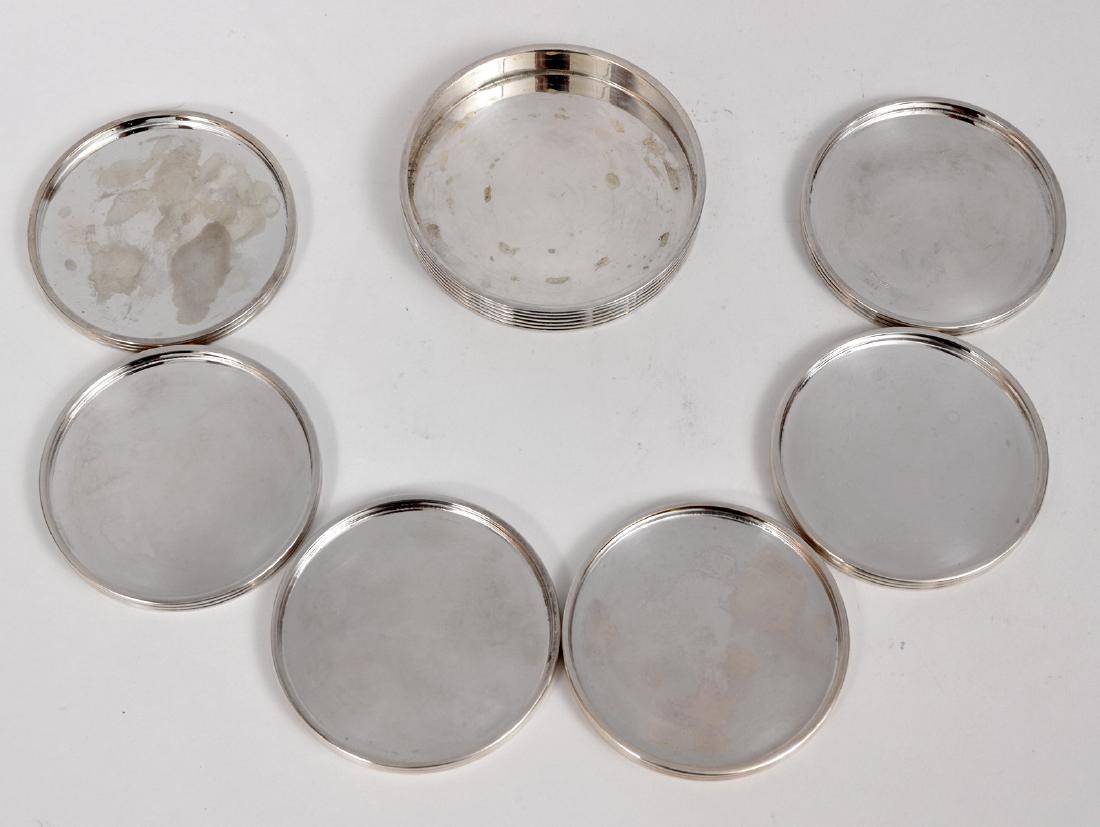 7 pcs Christofle Silverplate Modernist Coaster Set: 7 piece Christofle silver-plate modernist wine bottle coaster & 6 silver-plate glass coasters set. Wine coaster: 4"D x .75"H, Glass coasters: 3.5"D x .25"H. Marked on bottom: Christofle, K + T. Condit