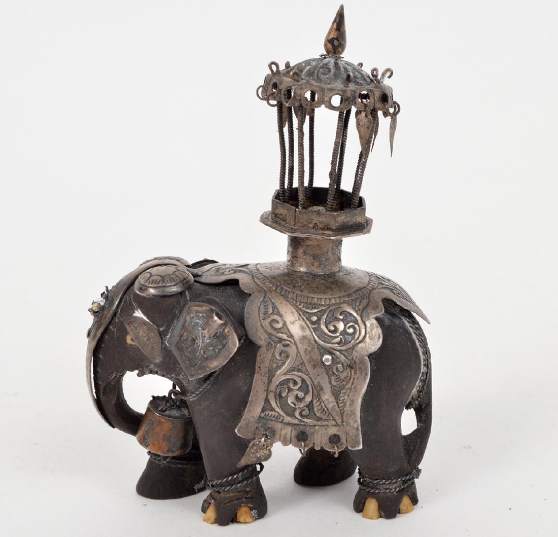 Antique Indian Ebony Silver Jeweled Elephant: Antique Indian ebony wood elephant, with jeweled silver covering and howdah. 3.75"H. Condition report: Good, howdah has some slight bending. Some dangles are missing from the elephants covering. Pleas