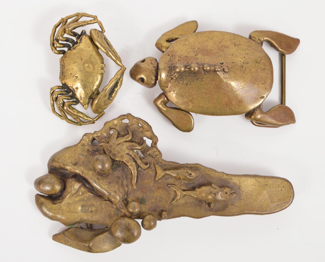 3 Carl Tasha Modernest Brass Belt Buckles Signed: 3 Carl Tasha modernest brass belt buckles. A turtle, a crab, and a ocean scene a crab and 2 fish. Signed. Sizes rang from: 2.25"-5"L. Condition report: Very good - no issues. Please examine all photos