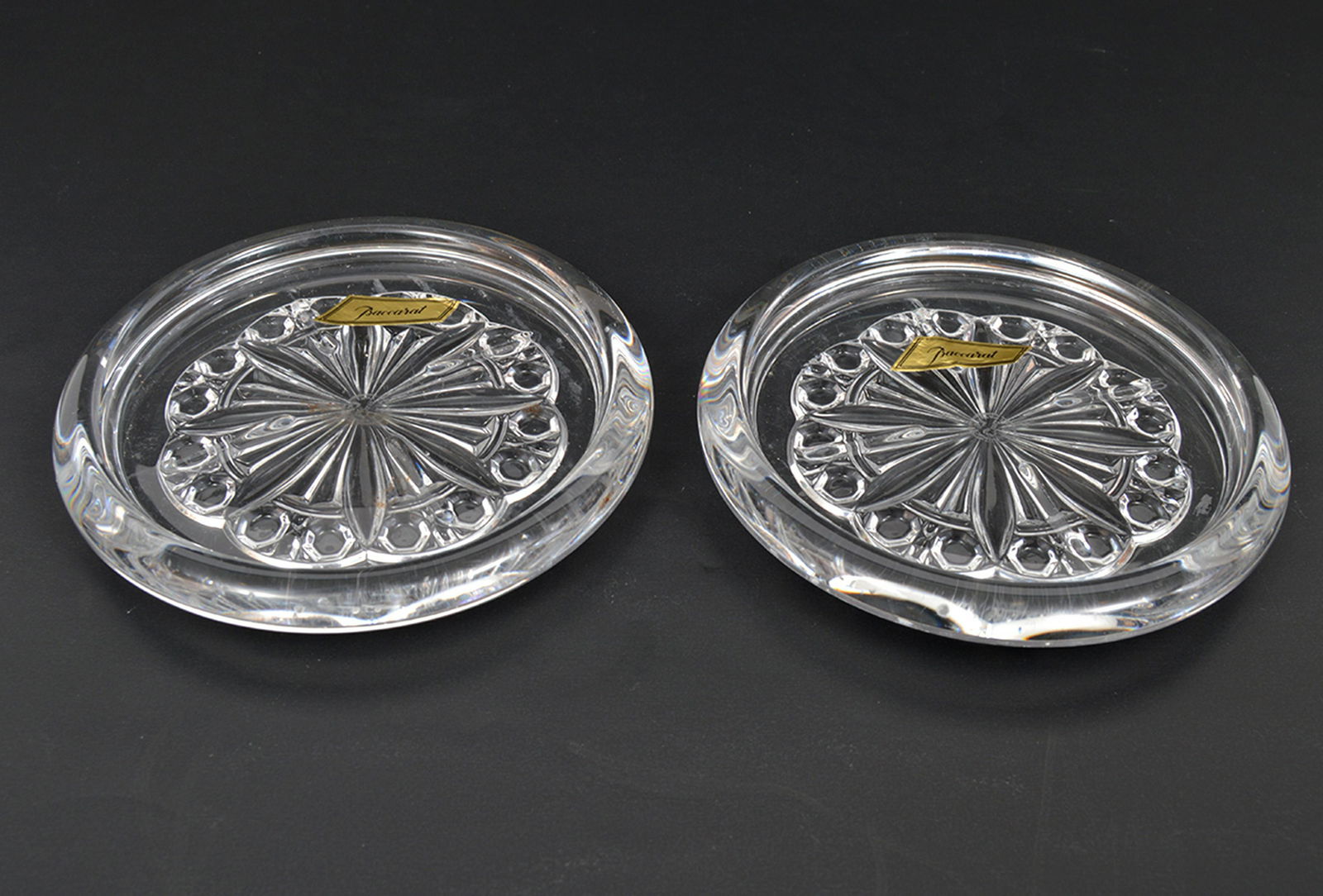 2 Baccarat Crystal Wine Champagne Bottle Coasters: 2 Baccarat crystal wine bottle coasters in original box. 5.5"D. Condition report: Very good - no issues. Please examine all photos closely. Contact C. Biddle Auction Gallery for more detailed informat