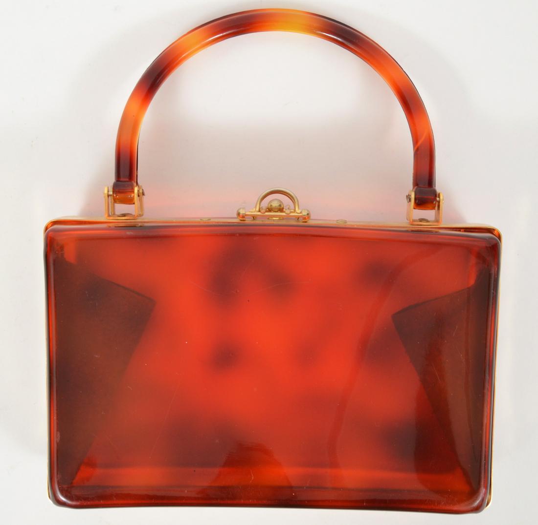 Vintage Tortoise Colored Lucite Handbag: Vintage tortoise colored lucite handbag with gold tone hardware. 6"H x 9"L x 3"D. Condition report: Good with some scratches. Please examine all photos closely. Contact C. Biddle Auction Gallery for m
