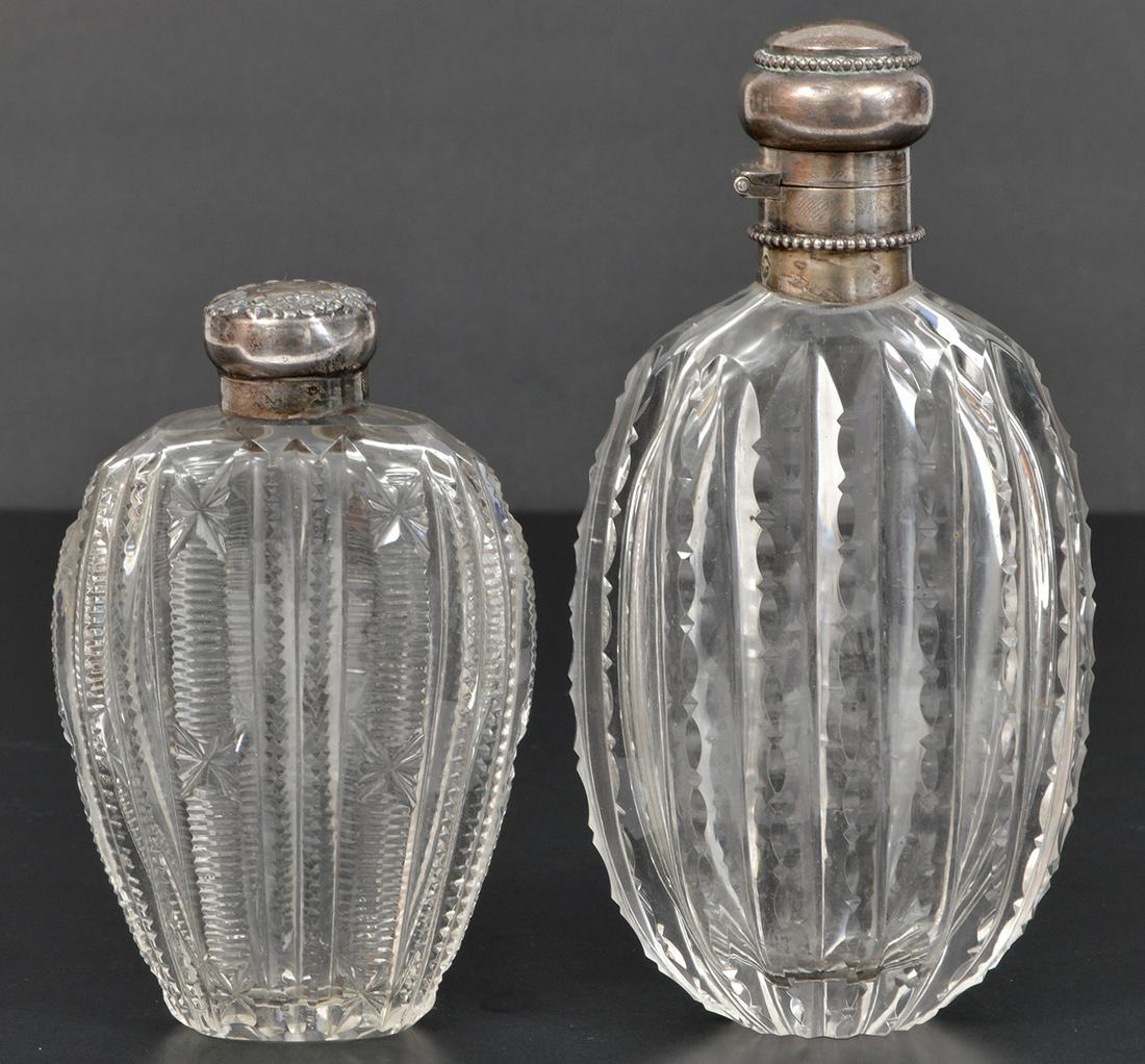 2 Antique Sterling Silver Cut Glass Flasks: 2 antique cut glass flasks with sterling silver tops. The smaller one has a repousse monogrammed top and is marked sterling and has an S maker's mark - 4.5"L. The larger one boast a sterling top with