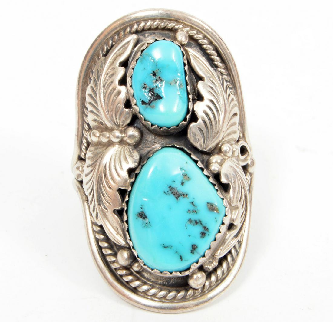 Native American Navajo Turquoise Sterling Ring 11: A large native American Navajo ring with 2 turquoise stones surrounded by sterling silver engraved leaves, beadwork and twisted rope designs. Size 11. Weight: 14.7 grams. Condition report: Very good -