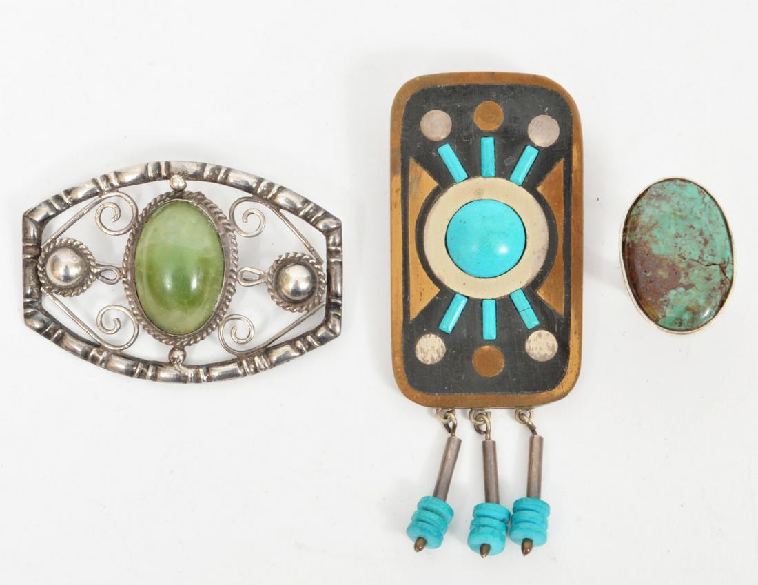 Mexican Sterling Brooches & Ring Turquoise Jade: A lot of 3 sterling silver jewelry pieces: a ring with a large vale bezel set turquoise, size 5.25, a brooch with a center jade cabochon in a open pierced design, 2.5"L, and a Piedra Negra brooch / pe