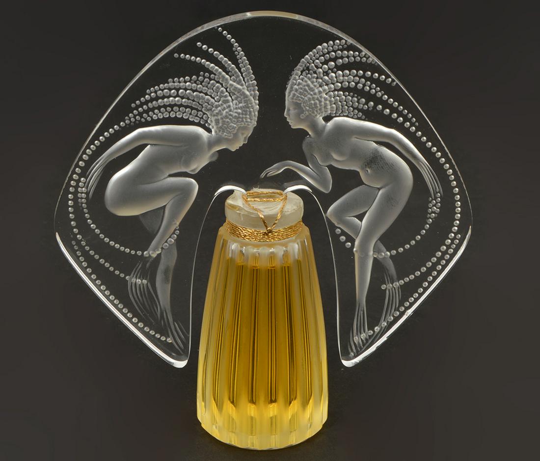 Lalique Parfum Ondines Flacon Collection 1998: Lalique parfum, Ondines, from the 1998 Flacon collection. 1oz. 5”W x 5.5”H. Condition report: New and sealed. Please examine all photos closely. Contact C. Biddle Auction Gallery for more detailed