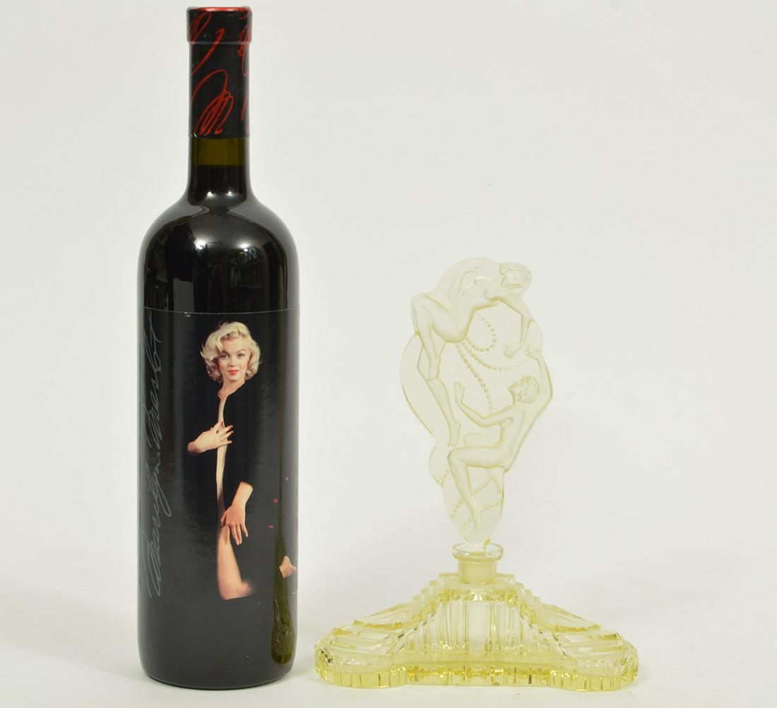 Vintage Yellow Sculptured Glass Perfume Bottle: Vintage clear and frosted sculptured yellow glass perfume bottle and figural intaglio oversized stopper with 2 nude figures, ridged and stepped base. Measures 8"H x 6"L x 2"W. Condition report: good c