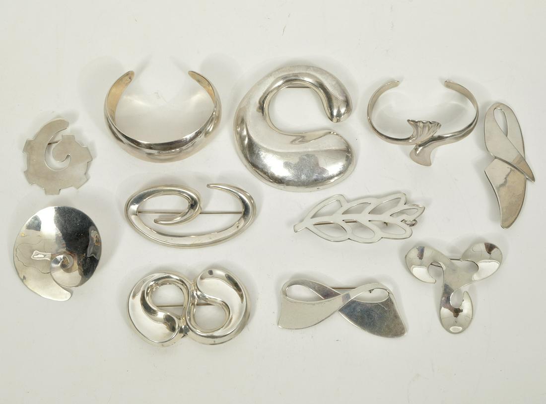 Mexican Sterling Jewelry 241g: Lot of Mexican sterling silver jewelry including 9 large brooches in various designs ranging in size from 1.75"L to 3"L and 2 cuff bracelets with a 5.5" inner circumference plus a 1.25" opening on bot