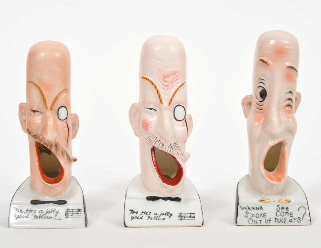 3 Ceramic Novelty Ashtrays w/ Wide Gaping Mouths: 3 ceramic novelty ashtrays of men with bald heads, wide gaping mouths to rest cigarettes and holes in their ears for the smoke. There are song lyrics on the bottom front of each. Measures 5.25"H x 2"D