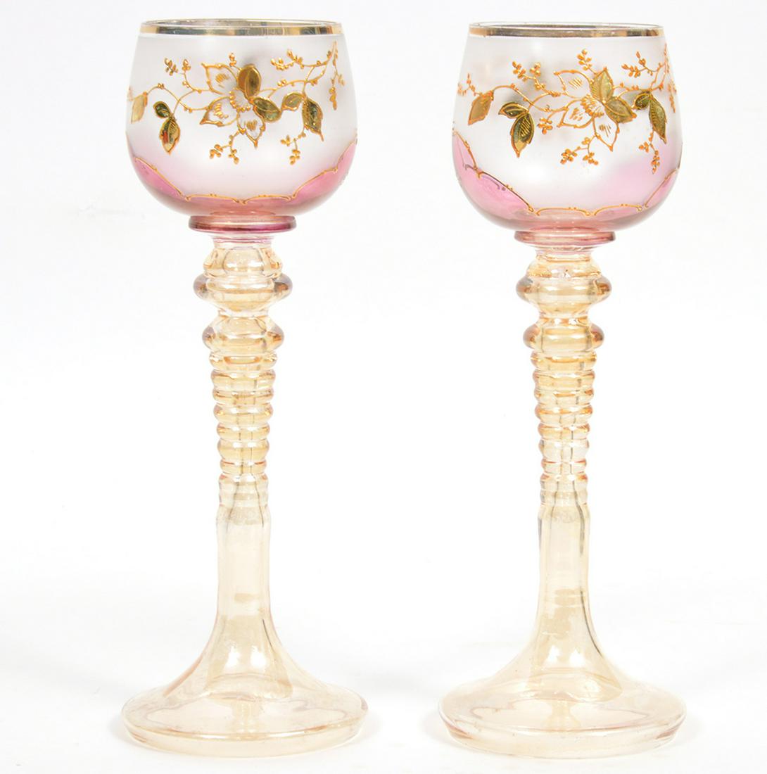 2 Bohemian Roemer Style Wine Goblets: Pair of bohemian hand painted enamel and gilt peach glass Roemer style wine goblets, featuring partial satin finish on outside of the bowl, with a gold and orange enamel motif. Measures 8.5"H x 3"D ba