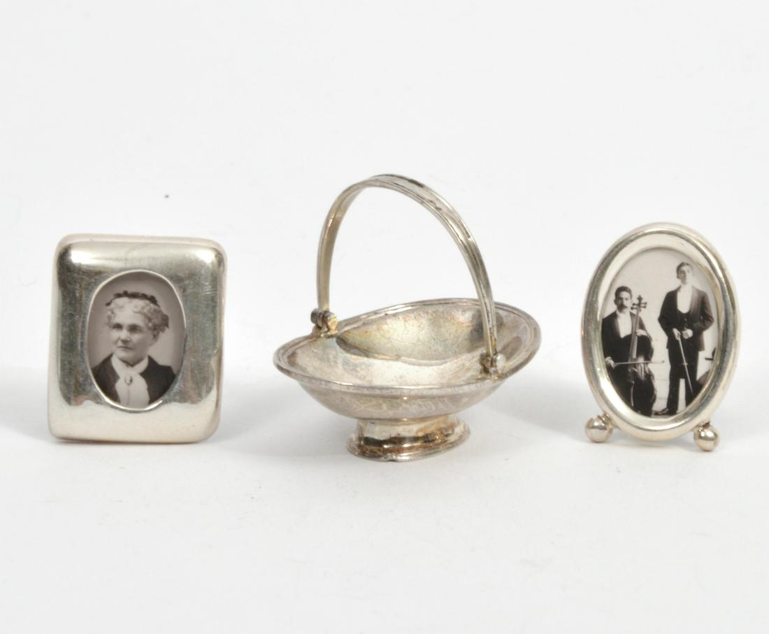 Miniature Sterling Bread Basket & 2 Frames: Miniature sterling silver oval bread basket by Pete Acquisto with movable handle, pedestal base (1"H x 1 1/8"L x 1"W); 2 picture frames, one oval one rectangle, with easel backs (.75"H). Condition rep