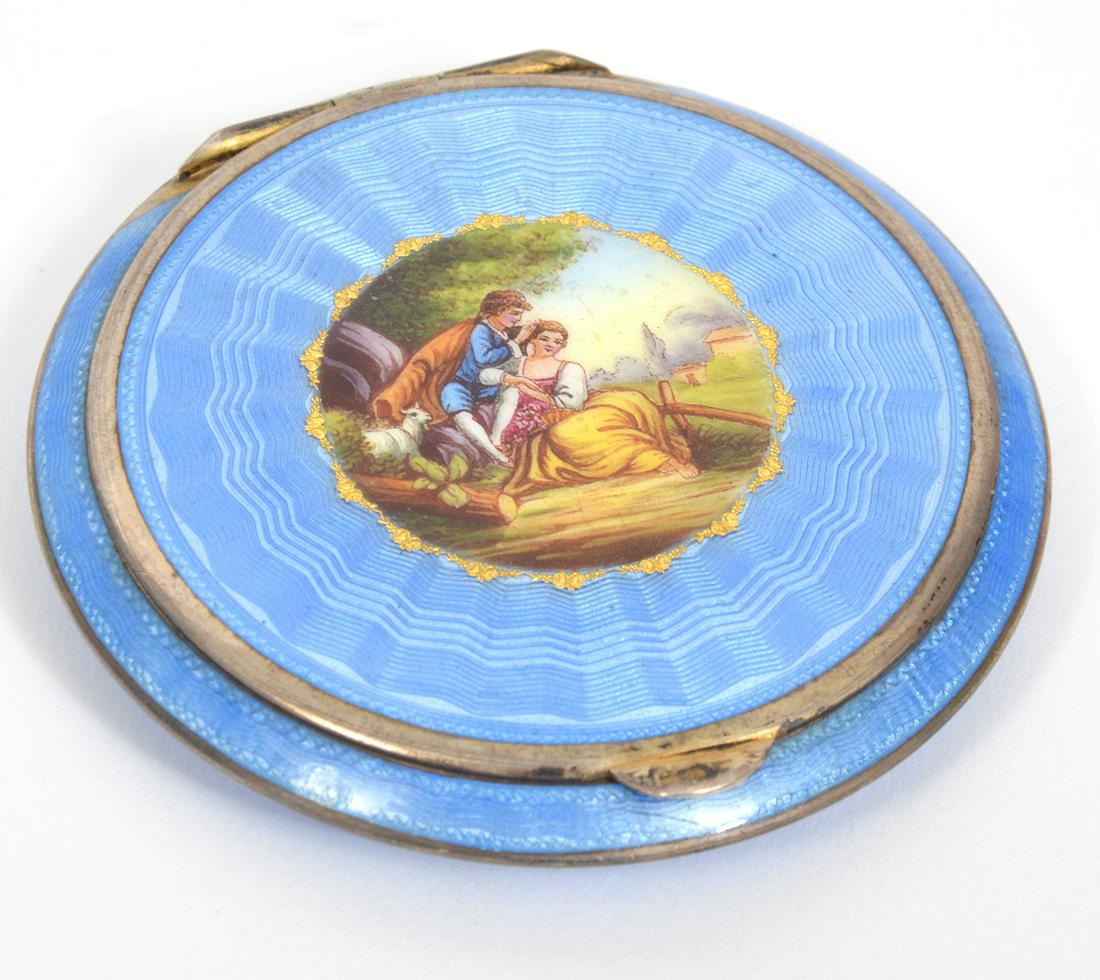 French Blue Guilloche Enamel on Metal Compact: French blue guilloche enamel on metal mirrored compact with romantic portrait in center. Measures 2.25" W. Condition report: Good condition, mirror has wear/spotting, please examine all photos closely
