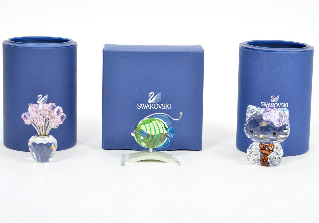 Swarovski Hello Kitty, Flower Bouquet & Fish: Includes: Swarovski crystal 'Hello Kitty' figure with pink bow and brown teddy bear. Measures 2"L x 1.5"W x 2.5"H; Swarovski crystal pink rose bouquet in clear vase, measures 2"W x 2.5"H; Swarovski cr