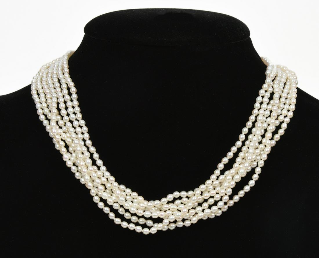 Gumps 14K YG 7 Strand Freshwater Pearl Necklace: Gumps 7 strand freshwater pearl Torsade necklace, stamped 'Gumps 14K' on Shou clasp. Features 7 strands of freshwater cultured pearls, individually knotted and a .5" oval shaped 'Shou' clasp. Measures
