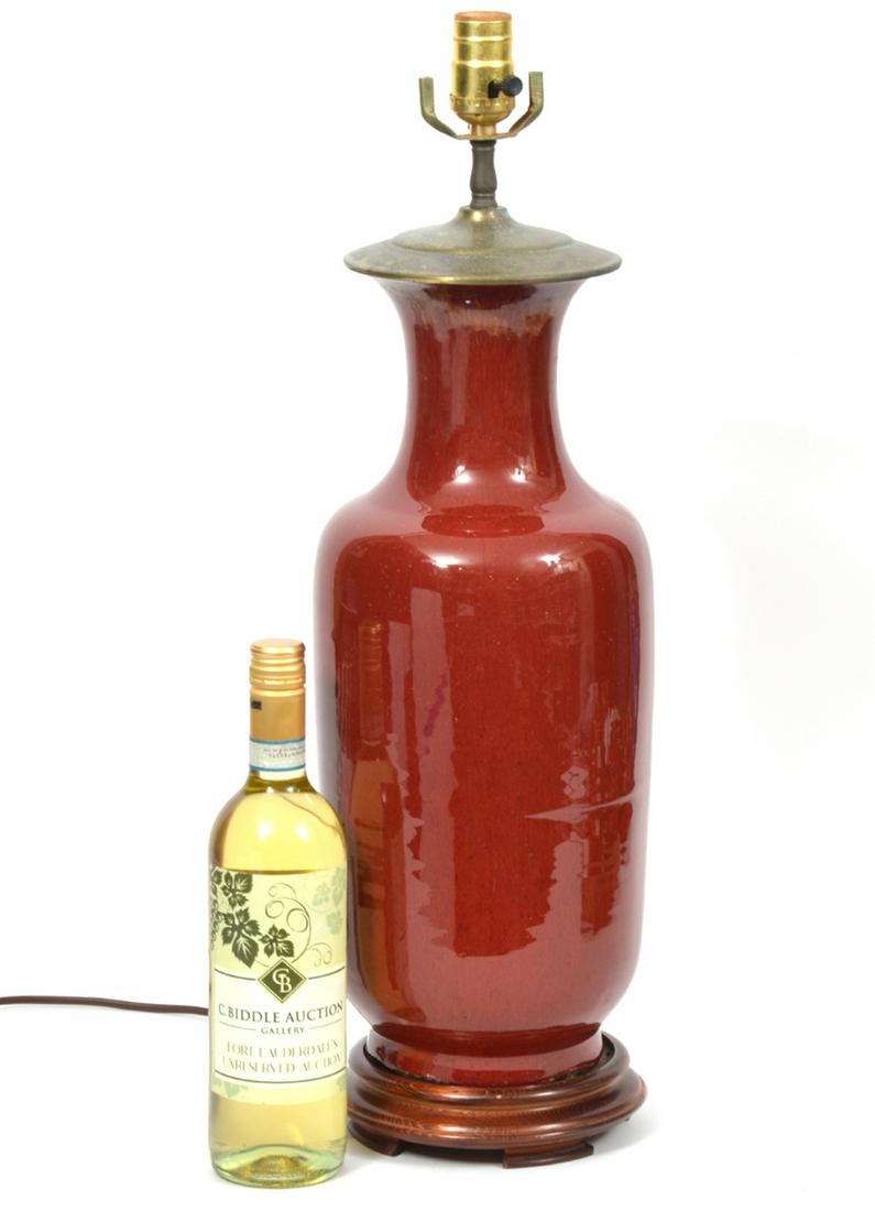 Chinese Oxblood Sang de Boeuf Vase Lamp: Chinese oxblood sang de boeuf vase converted to lamp. Fixture mounted onto round dark wood base. Vase measures 17.5"H x 7"W. Total height 34"H. Condition report: 2 cracks on rim with some restoration,