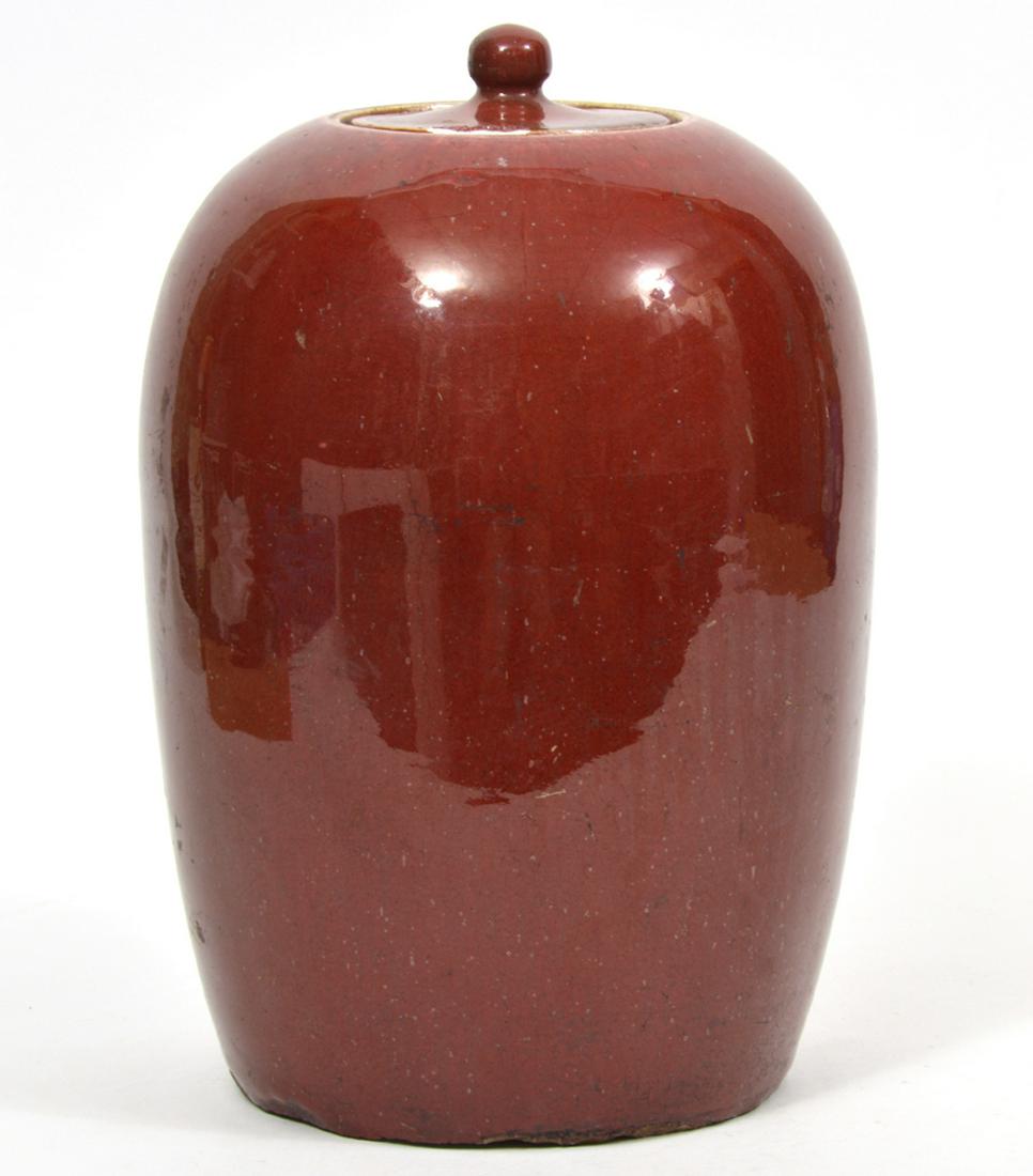 Chinese Oxblood Sang de Boeuf Covered Jar: Chinese oxblood sang de boeuf covered jar. Measures 8"W x 12"H. Condition report: Underside edge has chips. Other common light surface wear throughout. Please examine all photos closely. Contact C. Bi