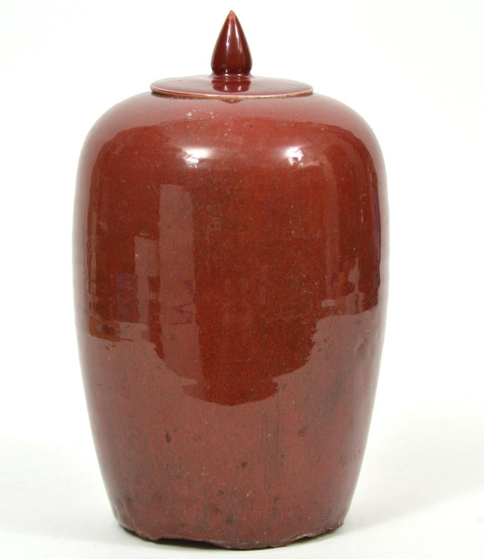 Chinese Oxblood Sang de Boeuf Covered Jar: Chinese oxblood sang de boeuf covered jar. Measures 7.5"W x 11.25"H. Condition report: Lid and Inner rim has chips/cracks . Underside edge has chips. Other common light surface wear throughout. Please