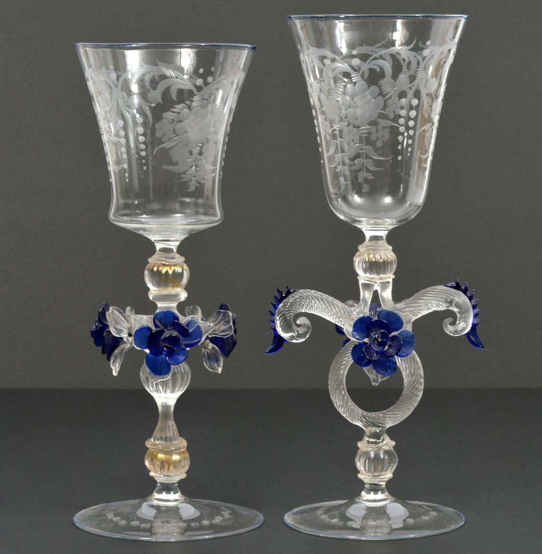 Pair of Venetian Hand-Blown Art Glass Wine Goblets: Pair of Venetian hand-blown art glass wine goblets, features twisted blue flower stem and etched floral design. Measures 3.5"W at base, 9.25" and 9.75"H. Condition report: Good condition, no issues, p