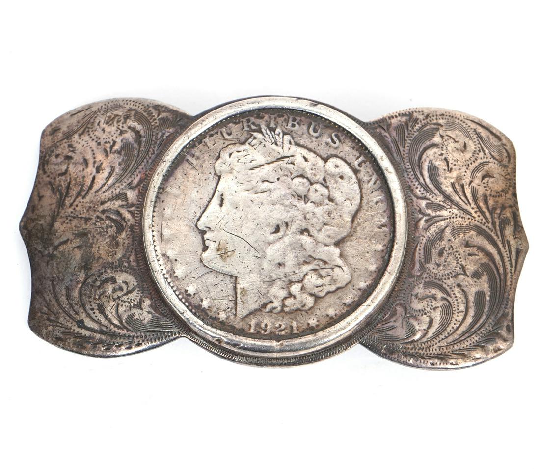 1921 Morgan Silver Dollar Sterling Belt Buckle: 1921 Morgan silver dollar mounted into a sterling silver belt buckle, marked "Newman's Reno Silver Shop". Weight - 54g. Measures 3"L x 1.25"W. Condition report: Good condition, common wear for age and