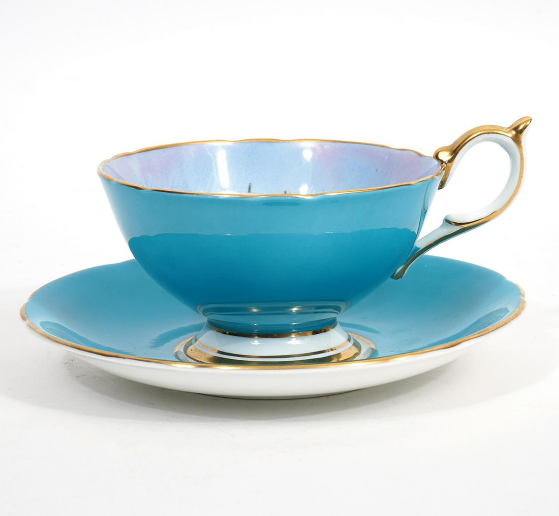 Aynsley Clipper Ship Tea Cup & Saucer: Aynsley English bone china tea cup and saucer, featuring large clipper ship on inside of cup and turquoise exterior. Signed bottom right corner. Cup measures 2.5"H x 5"W and saucer 5.5"W. Underside ha