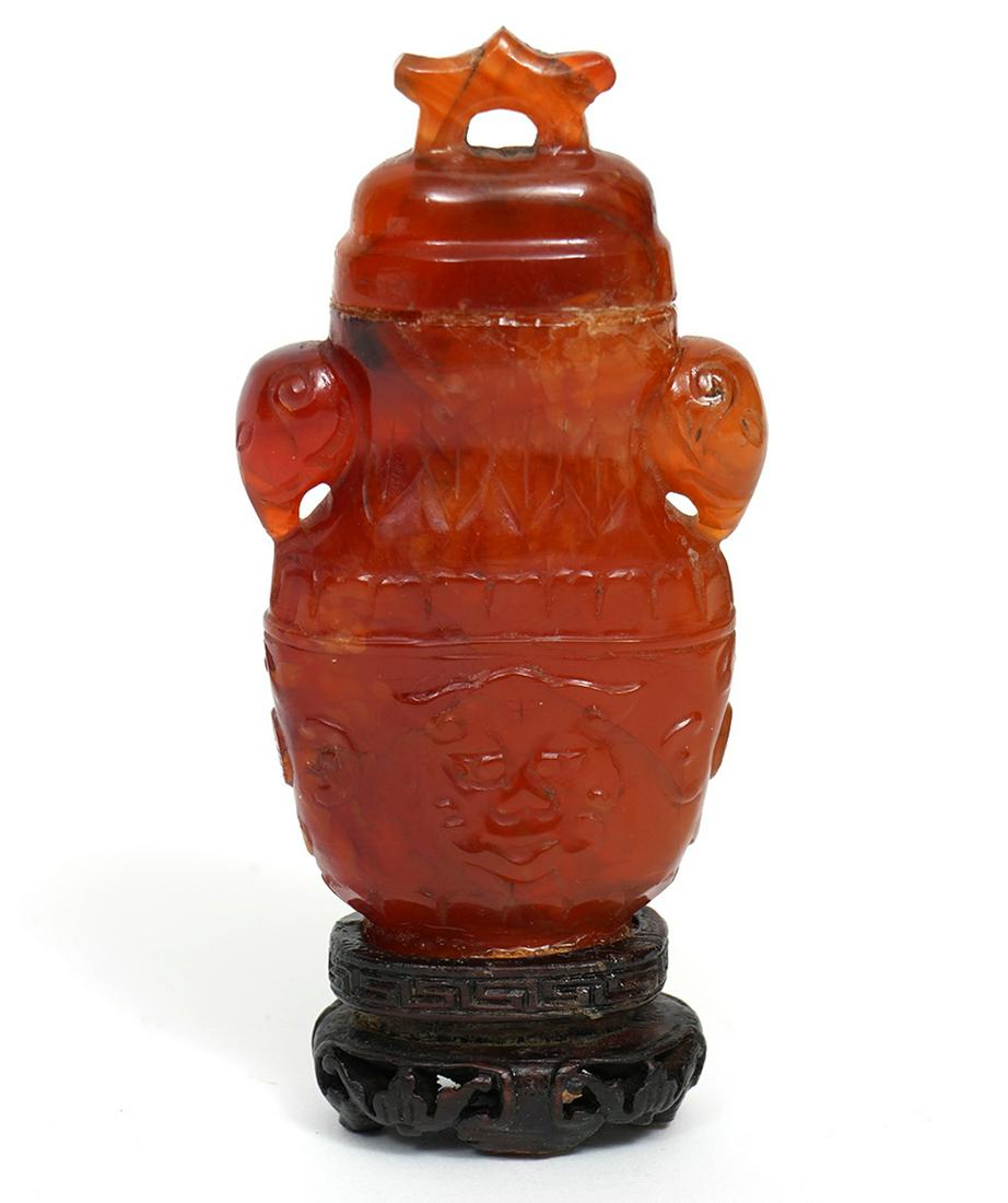 Chinese Carved Carnelian Miniature Lidded Urn: Chinese carved carnelian lidded miniature urn on wood base. Lid glued on and base is glued on. 3.25" H. Condition report: good condition consistent with ageand use. Please examine all photos closely. 