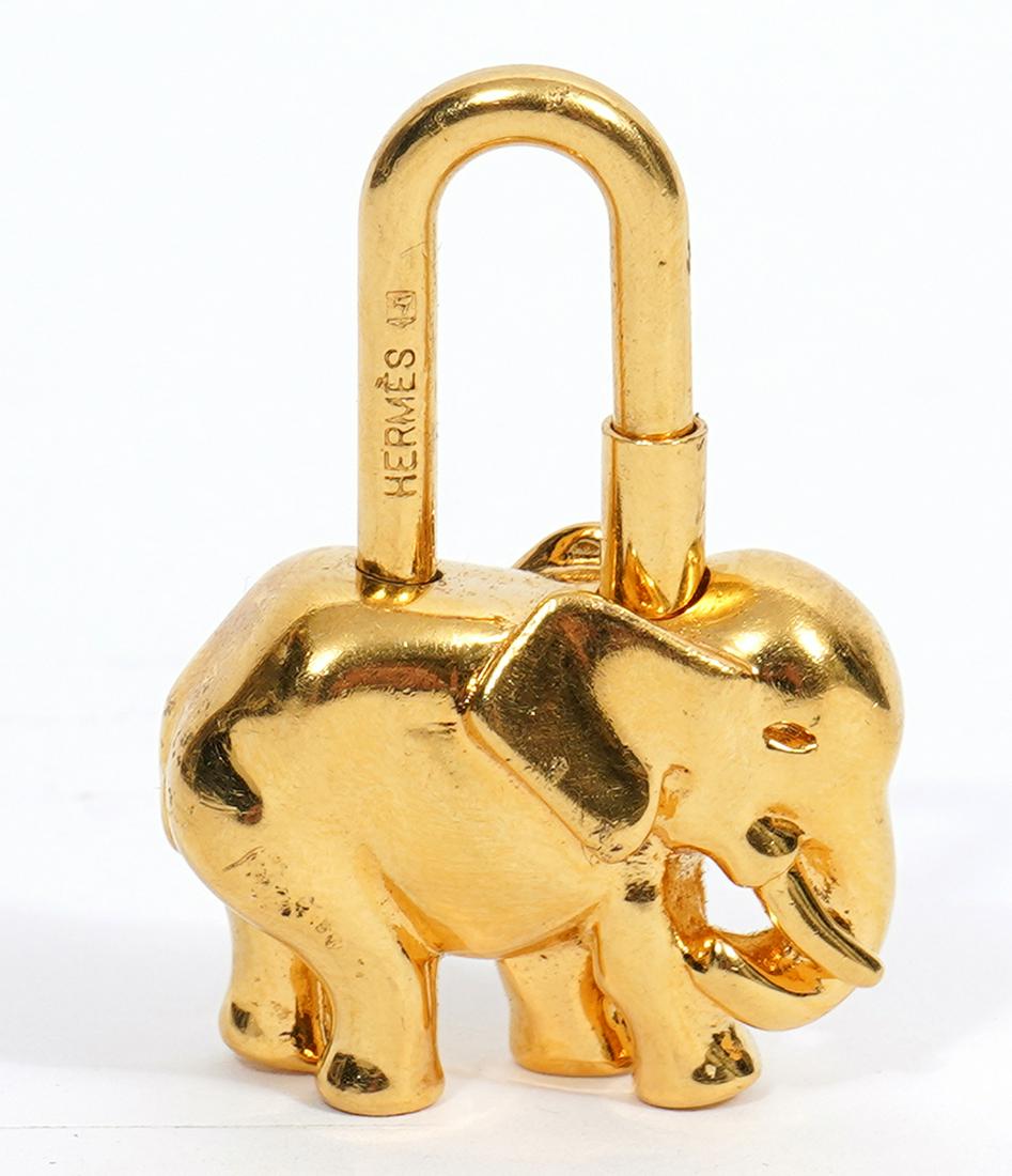 Hermes Elephant Cadena Padlock for Handbag: Gold plated Hermes Elephant Cadena padlock for handbag. Marked. 1.5" H x 1" W. Condition report: good with normal wear. Contact C. Biddle Auction Gallery for more detailed information. C. Biddle Aucti
