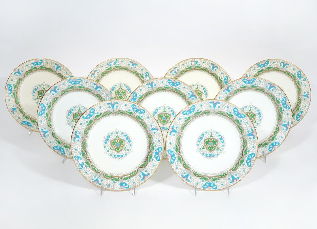 9 Minton China Plates Turquoise & Gilt on White: 9 Minton china plates with turquoise and gilt enamel designs around the rims and a circular design in the center. Measures 10.50"W, marked on underside. Condition report: turquoise enamel is chipped/m