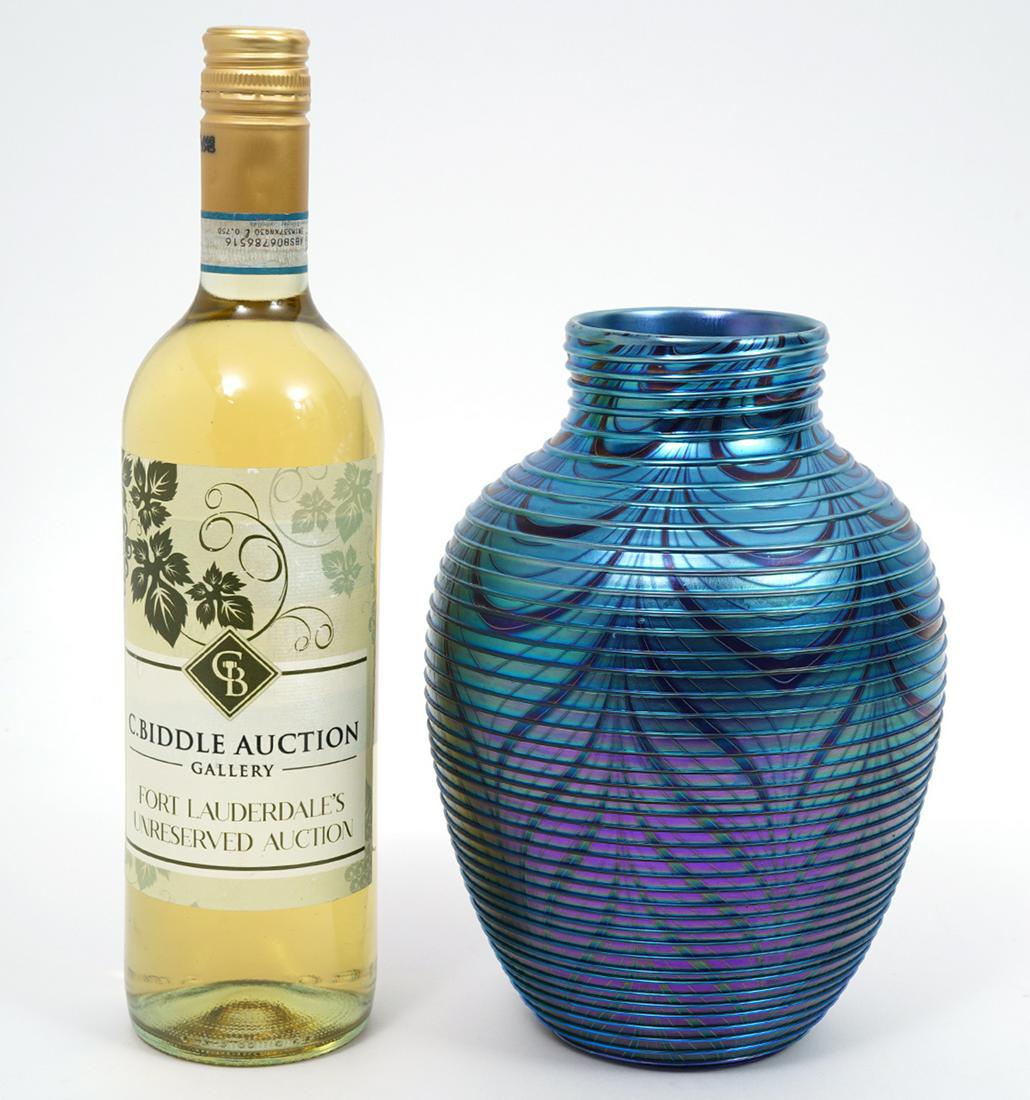 Orient & Flume Iridescent Blue Feather vase: Orient & Flume ribbed blue/gree iridescent vase with feathered designs. Etched on underside Orient & Flume 1982 F720. Measures 8.5"H x 5.5"W. Condition report: good condition, rough edges around botto