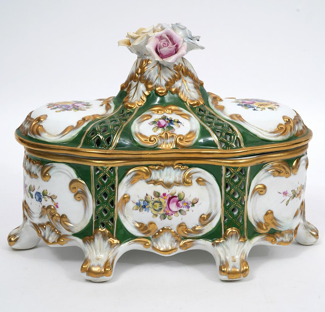 Meissen Style Porcelain Potpourri Box: Meissen style porcelain potpourri box, features gilt scrolling vignettes of flowers, and four rose finial. Pierced lid and body. Hallmarked underside. Measures 10.5"L x 6.75"W x 8.25"H. Condition repo