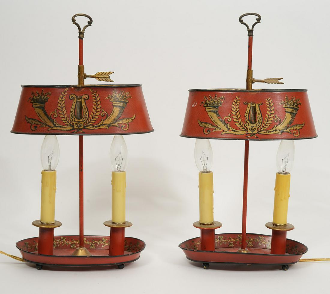 Pair of French Painted Tole Bouillotte Lamps: Pair of French painted tole bouillotte two light lamps, features red tone with gilt detail, harp flanked by wreath and two horns of plenty, base has vine motif on inside. Each measures 8.5"H x 5.5"W x