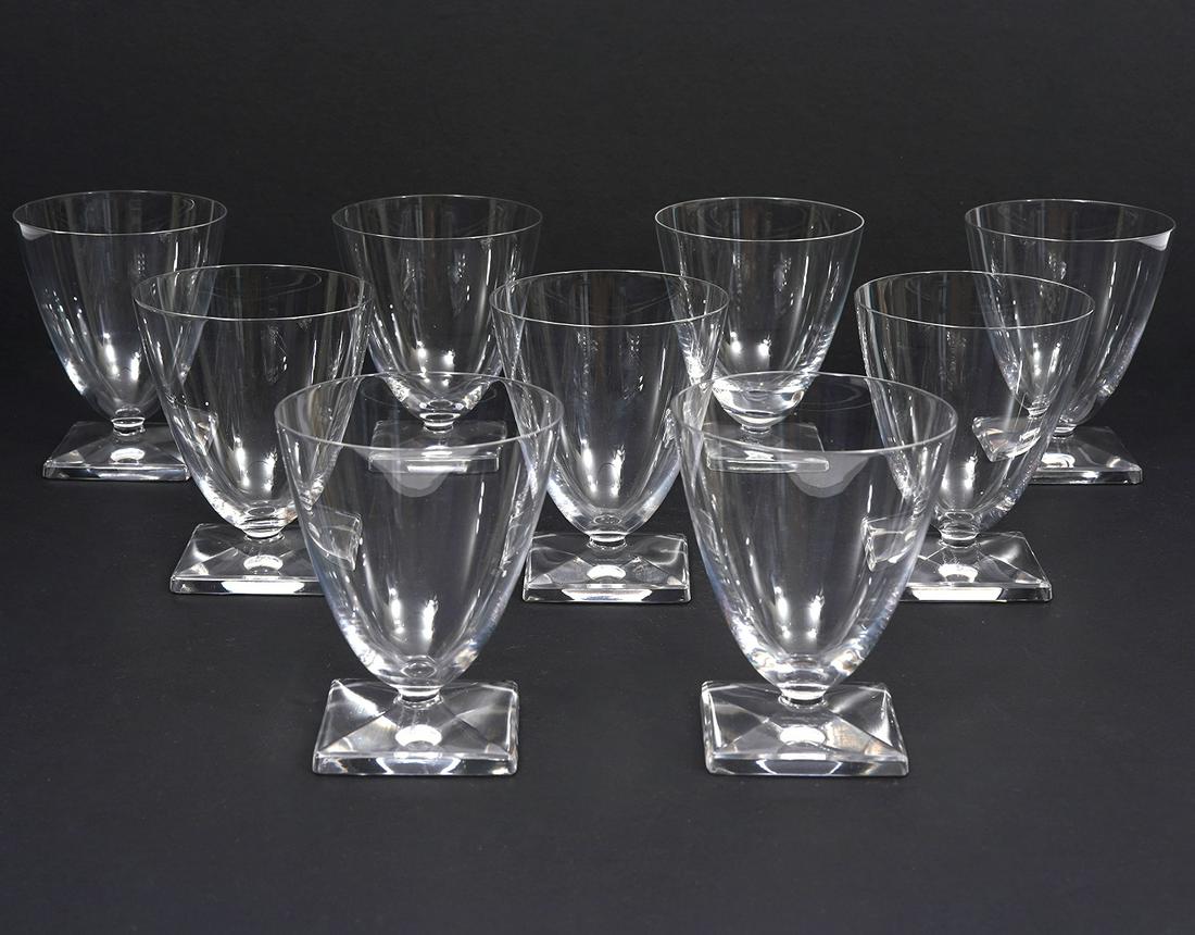 9 Lalique Contemporary Port Wine Glasses: 9 Lalique crystal port wine glasses, featuring contemporary modern design. Tapered form and beveled square foot. Hallmarked underside. Measures 2.75"W x 3.5"H. Condition report: Good condition, no iss
