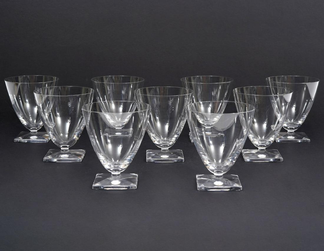 9 Lalique Contemporary Wine Glasses: 9 Lalique crystal wine glasses, featuring contemporary modern design. Tapered form and beveled square foot. Hallmarked underside. Measures 3.5"W x 4"H. Condition report: Good condition, no issues, Ple