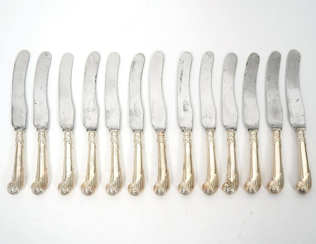 13 Mappin & Webb Silver-Plate Lunch Knives: Group of 13 Mappin & Webb silver-plate luncheon knives with scrolling pistol grip-style handles. Measures 8.5"L. Condition report: Common wear for age and use, please examine all photos closely. Conta