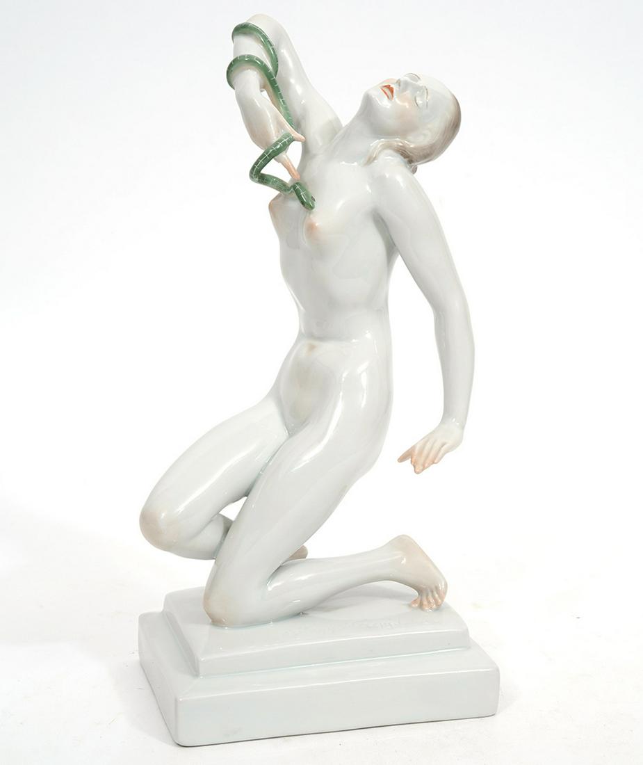 Herend Art Deco Figure 'The Death of Cleopatra': Herend porcelain figure, marked on underside. 'The Death of Cleopatra' white porcelain kneeling figure of nude holding a green snake to her chest. Measures 9.75"H x 4"W x 4.75"L. Condition report: goo