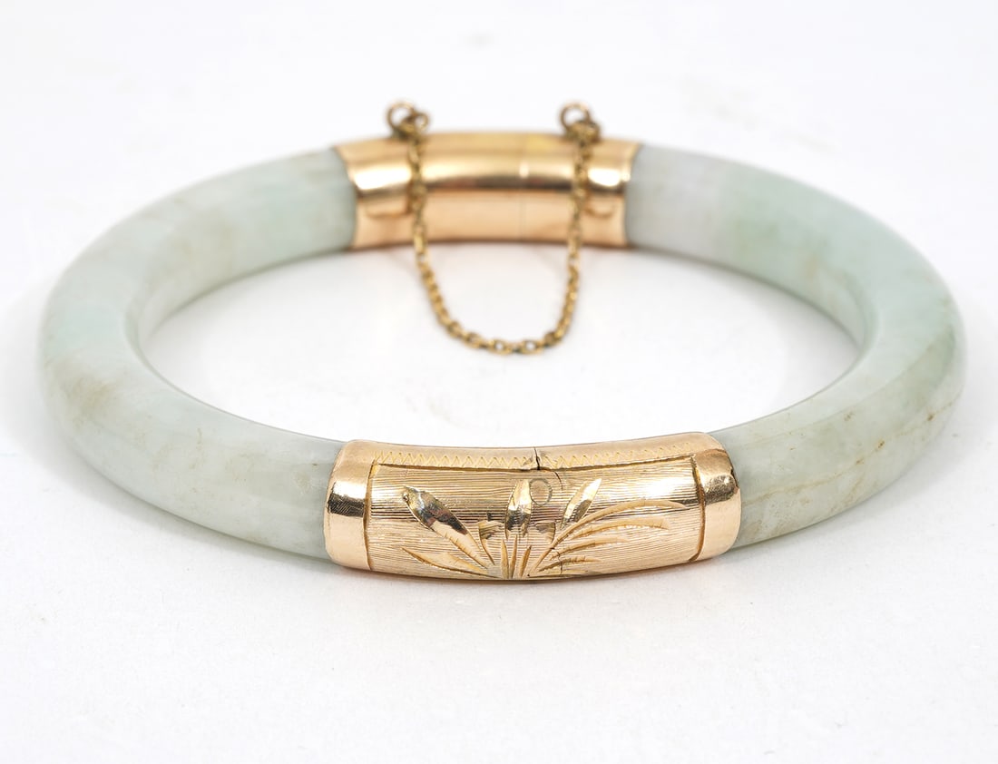 Jade Bangle with Engraved Gold Mounted Accents: Jade bangle with engraved gold mounted accents and safety chain. Approximately 7" inner circumference. Width 10cmm. Condition report: Good condition, please examine all photos closely. Contact C. Bidd