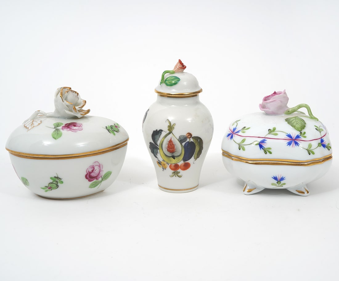 Three Herend Hand Painted Trinket Dishes: Three hand painted Herend trinket dishes include heart shaped 'Petit Rose' with gilt rimmed white rose finial (2.75"H x 3"L x 2.5"W); 'Rosehip' pattern urn shaped lidded piece with gilt rims and small